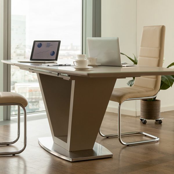 Image of work desk with two laptops on it and comfortable armchairs beside in bright office interior with large windows and urban landscape outside. Modern office workplace, negotiation room design